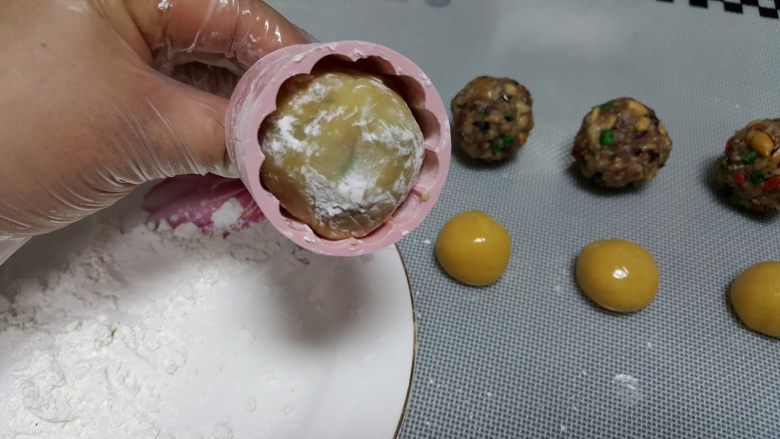 广式月饼~五仁馅儿,11．模具选好自己喜欢的花片后，将月饼胚塞入模具中进行压制。