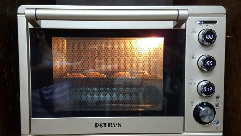 广式月饼~五仁馅儿,13．在月饼生胚上，喷少量的水，放入已经预热好的烤箱中上下火180度，烤7分钟取出后，表面刷薄薄的一层蛋黄水，继续放入烤箱中，上下火180度