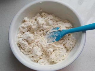 红糖椰蓉三角包,然后将牛奶液倒入面粉中，先搅拌成棉絮状；