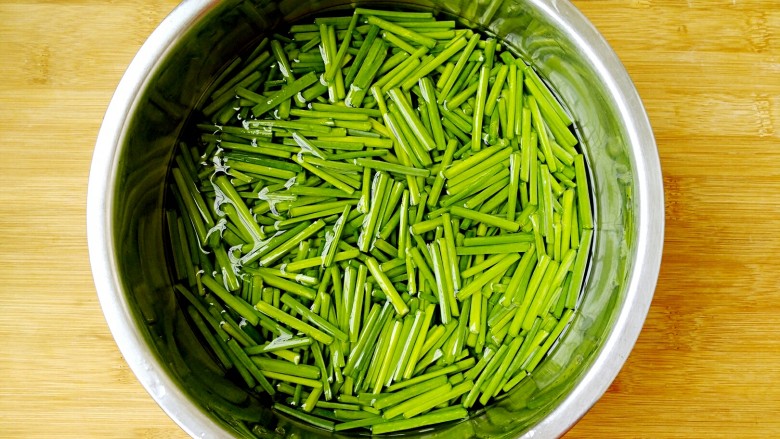 韭菜苔炒香干,把切好的韭菜苔放入装有清水的盆中，泡十分钟。