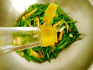 韭菜苔炒香干,加入料酒10ml，继续翻炒均匀。