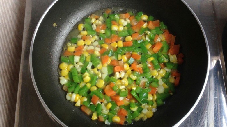 三色鲜蔬盏,放入玉米粒、胡萝卜粒和青椒粒。加入盐和糖翻炒片刻，放入适量的水，煮三分钟左右。