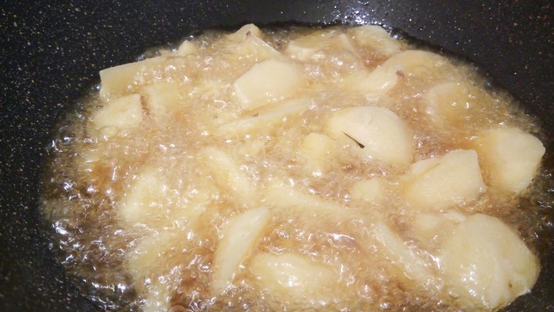麻辣鲜香土豆块,等油温升高，放土豆块大火炸，先不用去翻动它，土豆外皮定型以后，再翻面炸