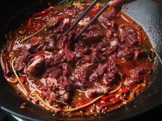 麻辣滑嫩的水煮牛肉,把牛肉倒入锅内划散，烫至肉片变色后立刻捞起放入装着豆芽和油麦菜的碗中；