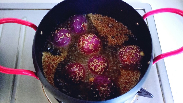 芝士紫薯球#附紫薯泥制作#,油温7成时加入包好的芝士紫薯球。中火炸2分钟即可。