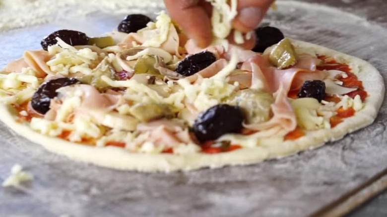 卡布里乔莎披萨,现在，在披萨上放上洋蓟 ，火腿片 ，黑橄榄 ，蘑菇（切片） (2 个) ，水牛马苏里拉芝士（刨碎或切丁） 。