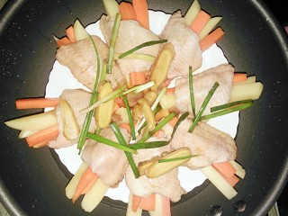 胡萝卜土豆酿鸡翅,把腌制鸡翅的姜葱，酱汁倒入鸡翅里，上锅蒸25分钟就好了