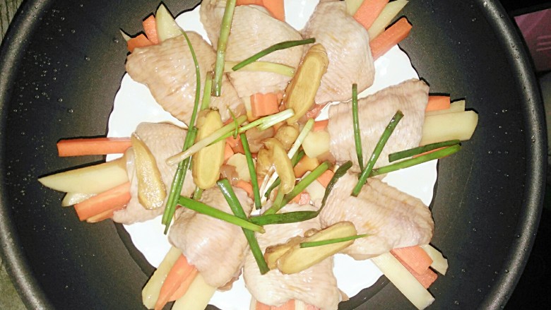 胡萝卜土豆酿鸡翅,把腌制鸡翅的姜葱，酱汁倒入鸡翅里，上锅蒸25分钟就好了