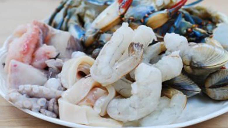 辣味海鲜火锅,把新鲜蛤蜊 泡在盐水（2杯水加1汤匙盐）中，搓洗干净，至少浸泡30分钟，让蛤蜊吐沙。打开蓝色梭子蟹 的蟹壳，去除腮。