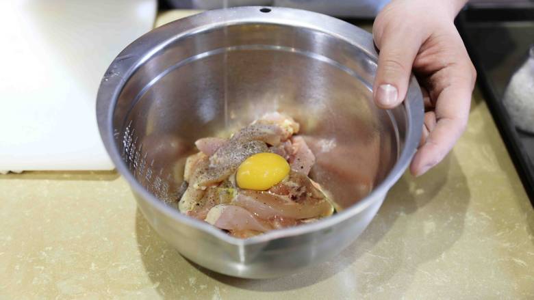 香烤蜂蜜辣鸡块,把鸡肉放入搅拌碗,放入鸡蛋 与鸡肉拌匀