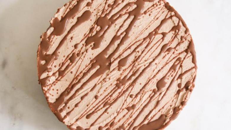 巧克力曲奇盒装蛋糕,用尖刀将蛋糕取出，用勺子在蛋糕表面和旁边撒上能多益混合物，等待1-2分钟凝固，没有的话再冷冻几分钟