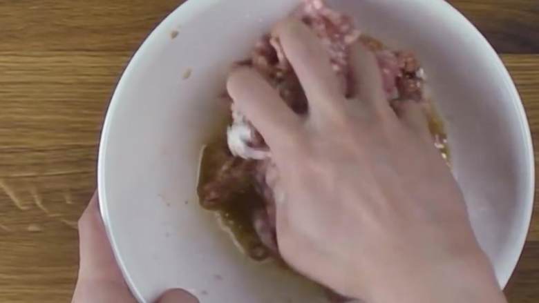猪肉虾烧麦,用手勒紧混合调味的磨碎猪肉，不断砸进搅拌碗里，直到它保持面团状