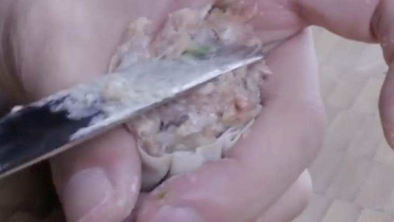 猪肉虾烧麦,在一只手里拿一片馄饨皮，用黄油刀或勺子钝的那端舀3/4-1汤匙的混合物到皮里，然后包裹成上面镂空的圆筒状
