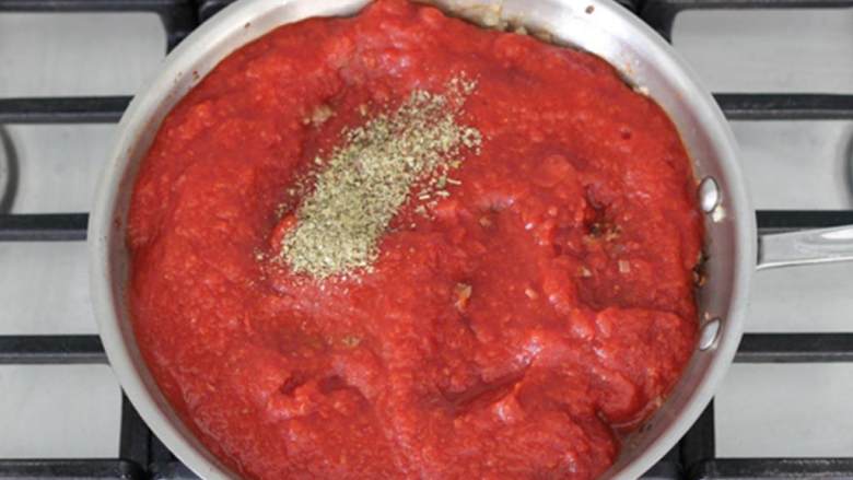 懒人版千层面,倒入番茄罐头 ，撒上干香草 ；混合均匀后继续煮8-10分钟，盖上锅盖，用中小火。