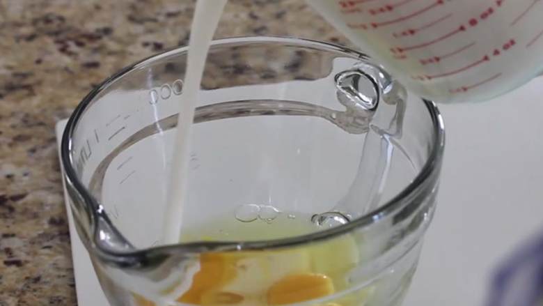 空心松饼,倒入百分之二脂含量牛奶 ，用打蛋器打匀，至呈现淡黄色且略微起泡。
