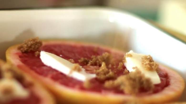 柑曼怡炙烤葡萄柚,葡萄柚切面朝上放置在烤盘中，每半个葡萄柚都撒上柑曼怡酒 ，放上红糖 和黄油 。