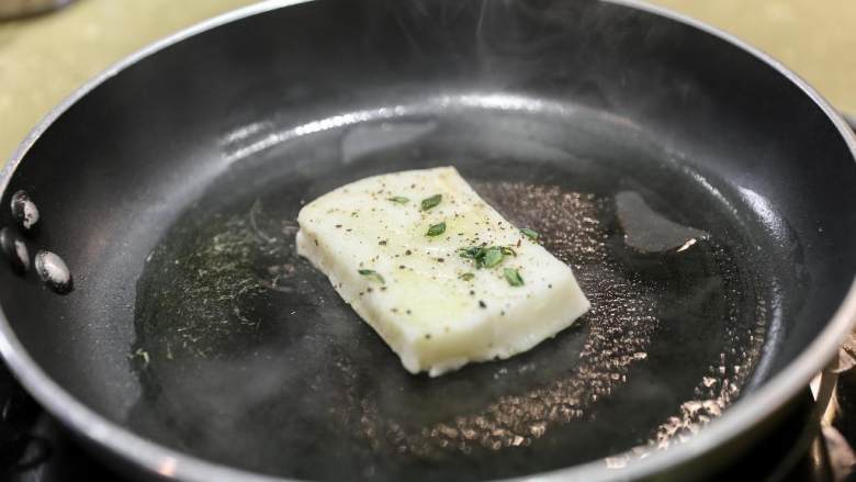 南法风味香煎银鳕鱼,取出腌制的鱼吸干油，撒上黑胡椒和盐 鱼皮朝下的先煎到7-8分熟。