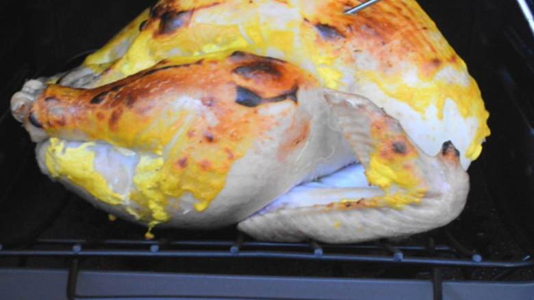 感恩节火鸡,把烤箱温度调低至175摄氏度，把温度计插入火鸡肉最厚的地方，继续烤火鸡，直到火鸡内部的温度达到70摄氏度，大概还需要2.5到3个小时。