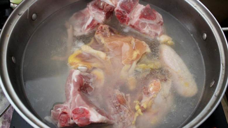鸡肉火锅,把鸡 切成大块；洗净鸡肉和猪大骨 ；取一只大汤锅，倒水烧开；加入鸡肉和猪骨；当汤水表面浮起血沫时，捞出鸡肉和猪骨，把鸡肉再切成小块。