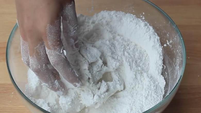 麻团,取一个大碗，混合剩下的糯米粉 、糖 、 泡打粉 ；把冷却好的小面团也放进去；慢慢地加入水 ，不断揉捏，直到形成光滑的面团。