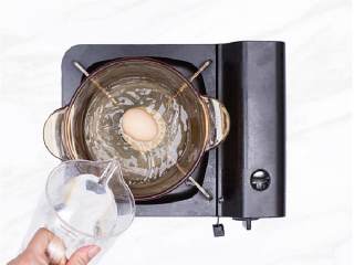 东南亚风叻沙米粉,煮锅中加500毫升水，煮开后加入鸡蛋 ，煮7分钟后捞出，冲冷水，去除鸡蛋壳。