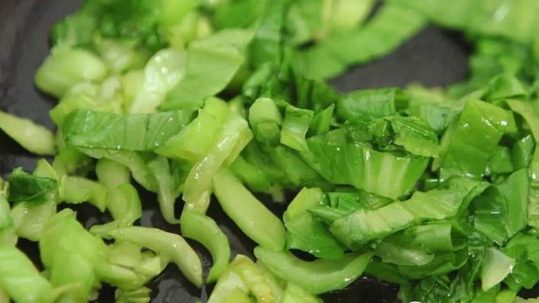 上海菜饭,放入青菜叶，稍微煸炒一下，变软即可关火，可以适当放一些盐提味。