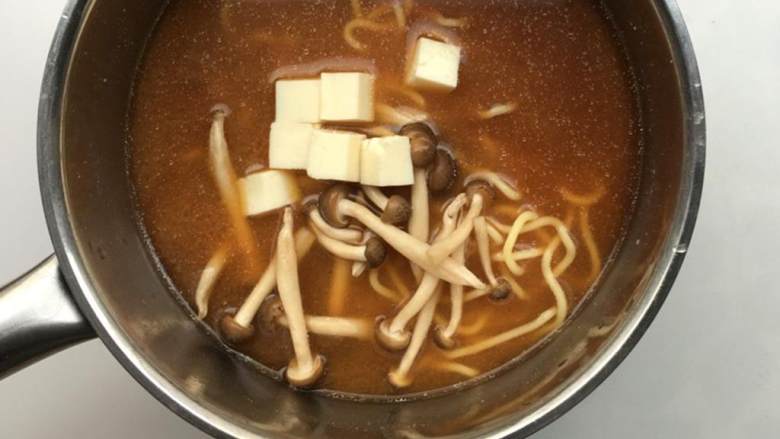 日式味增拉面,使面条在味增汤中浸泡几分钟，知道面条散开。加入豆腐块 和蘑菇 ，加胡椒 调味。