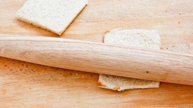 日式亲子面包卷,用擀面杖把面包压平压薄。（也可以用红酒瓶代替擀面杖）