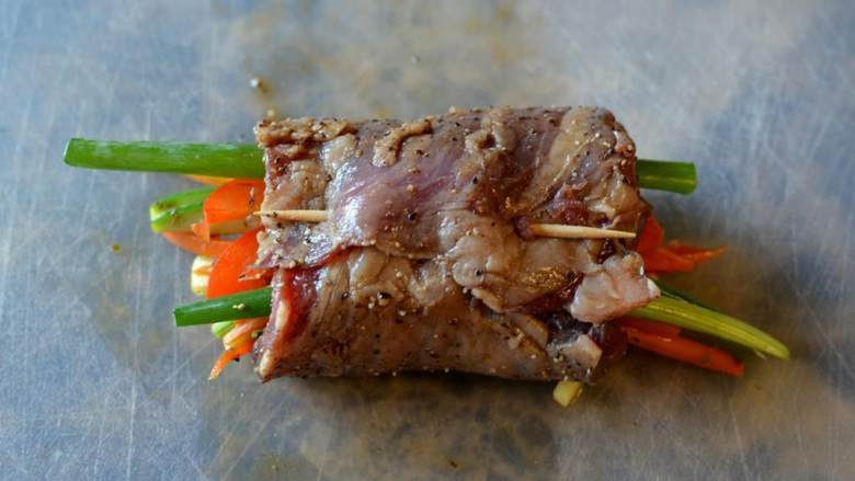 香煎牛排卷,用牙签固定牛肉卷。重复上述步骤，直到卷好剩下的所有牛肉和蔬菜。