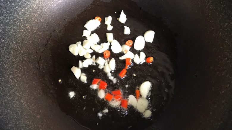 酸辣土豆丝,锅中倒入适量油，放入大蒜和小米椒炒香