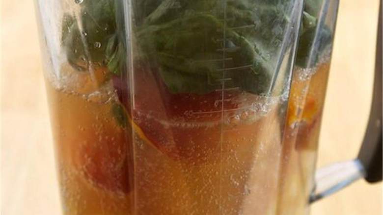 桃子凤梨姜奶昔,把切好的水果放进搅拌机中，倒入姜康普茶 、菠菜 。