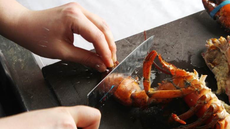 波士顿龙虾海鲜饭,然后用刀背敲下龙虾的两个大钳子，把壳敲碎。