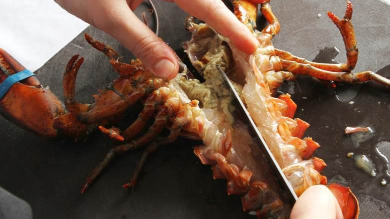 波士顿龙虾海鲜饭,然后反过来，在龙虾的腹部上切一刀直至尾部。