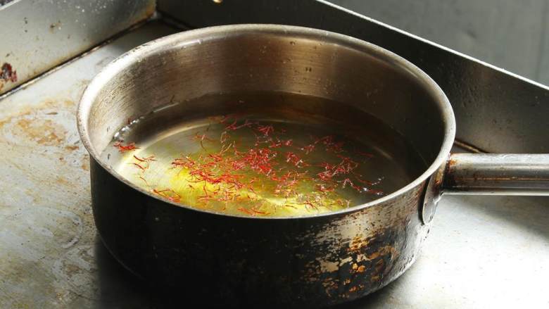 波士顿龙虾海鲜饭,在锅中倒入水 和藏红花。煮沸后离火。然后再加热龙虾高汤(900 毫升)备用。