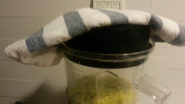 韭葱土豆奶油汤,用毛巾盖住搅拌机上的孔，但不要完全覆盖。