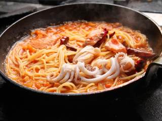 意大利海鲜面,加入事先焯熟的意大利面翻炒均匀，加上切碎的小番茄装盘即可