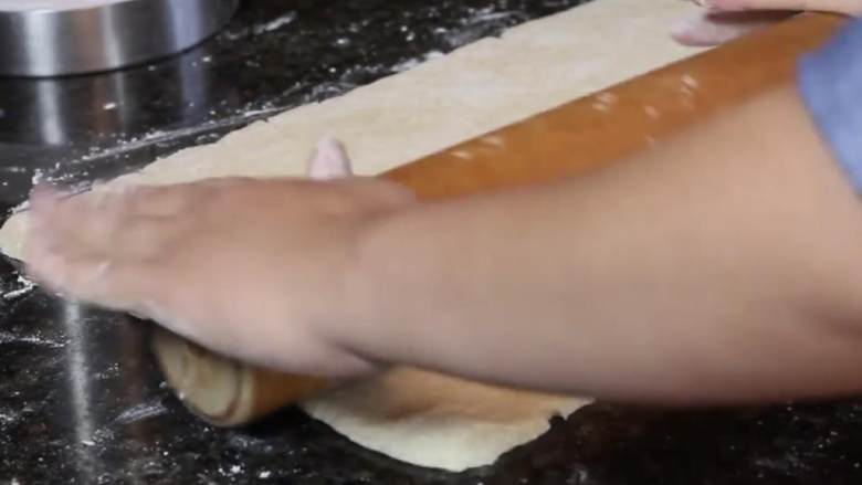 苹果酱馅饼,将烤箱预热到205度，将面团放在烤盘纸上。在撒了面粉的案板上，尽你所能将面皮擀成长方形，直到约0.5厚。