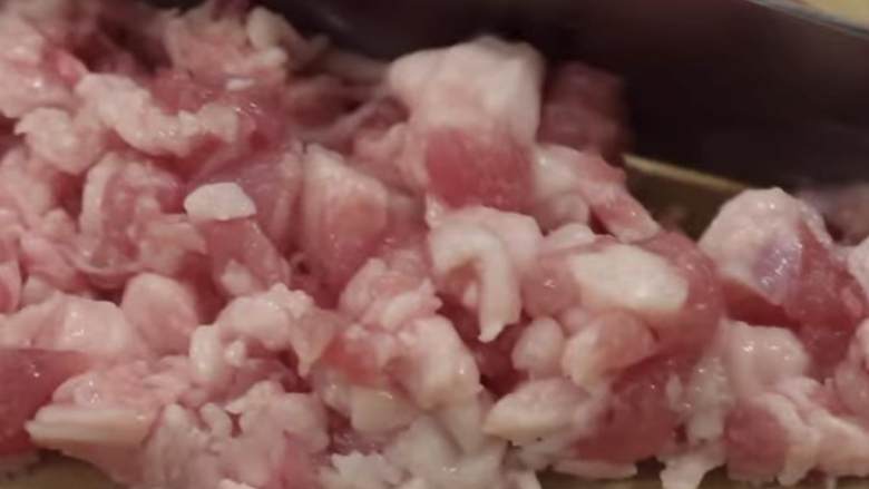 猪肉鲜虾烧麦,用刀进一步把它砍碎。如果猪肉太大了，它的味道就不好了。
