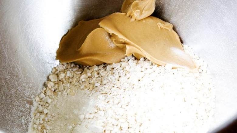 自制蛋白棒,在一个碗中混合燕麦面粉, 燕麦片 和花生酱。