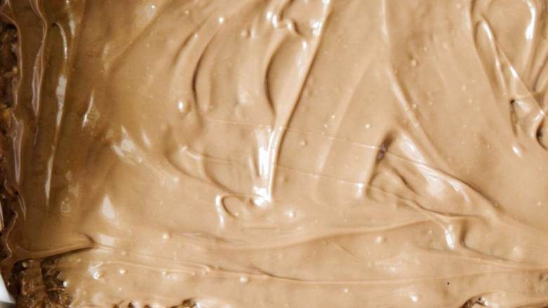 自制蛋白棒,融化黑巧克力 ，涂在顶上，然后放入冰箱冷藏约30分钟。