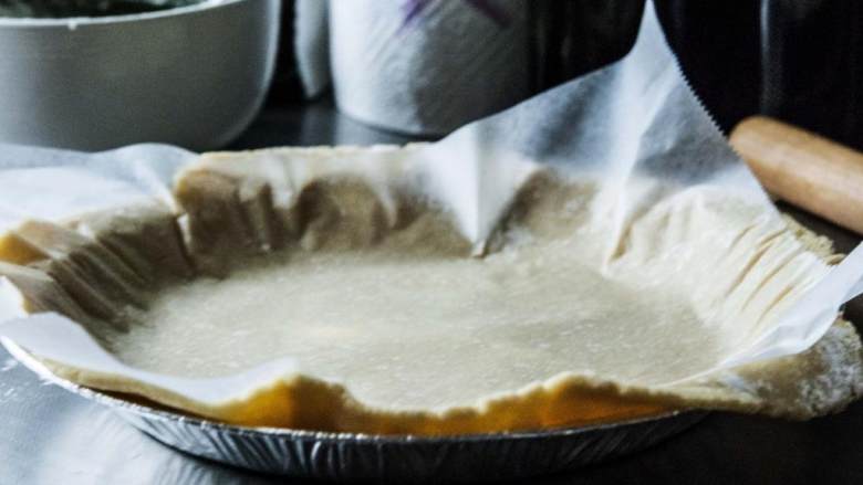 草莓奶冻派,烤箱预热到180度。在厨房案板上撒一层面粉，用擀面杖把面团慢慢擀成3毫米厚的圆饼。