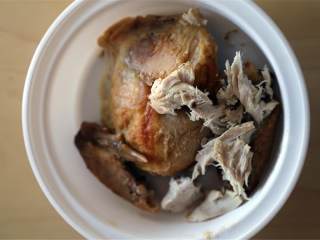 越南风味鸡肉米粉汤,用手将吃剩的烤鸡肉 撕成条状。