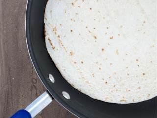 烤鸡肉卷,在锅中加热面粉制墨西哥薄饼(2)，让薄饼更容易包裹，每面需要1分钟左右。