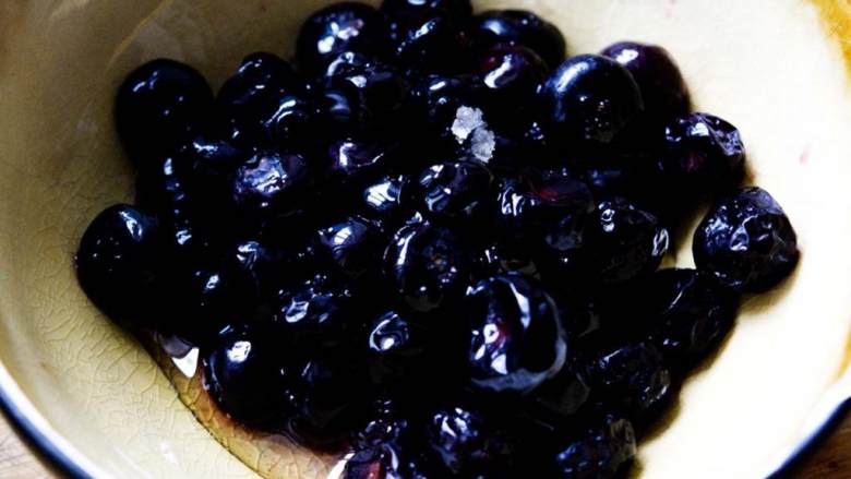 蓝莓酸奶冰棍,拿出冷冻蓝莓 待其慢慢完全解冻。然后倒入一半蜂蜜。