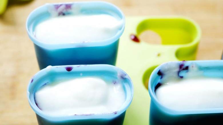 蓝莓酸奶冰棍,最后倒一汤匙酸奶，然后插进盖子放进冰箱冷冻3-4小时。