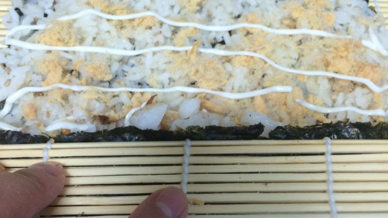 鳕鱼肉松寿司,用竹帘协助卷起来，中途卷一下往下压一下，这样结实一些