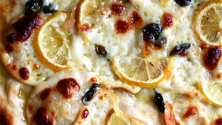烟熏意大利干酪柠檬披萨,把3盎司奶酪铺在表面，留下一个1英寸边缘。把柠檬片和新鲜罗勒叶放在奶酪上，浇上特级初榨橄榄油。