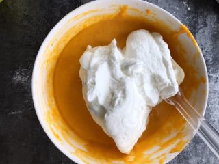 南瓜戚风蛋糕,取三分之一蛋白霜加入蛋黄糊中翻拌均匀