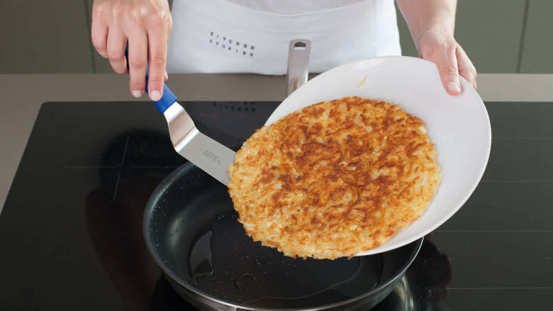 炸薯饼佐煎蛋培根,在锅中加入半份<a style='color:red;display:inline-block;' href='/shicai/ 857'>植物油</a>并以中大火加热。倒入土豆丝使它们均匀地铺在锅上。此过程中无需翻动，约五分钟后土豆丝底部变金黄并形成脆皮。用一个大碟子盖住平底锅帮助翻面，煎制另一面。此过程大约为五分钟，按需加入<a style='color:red;display:inline-block;' href='/shicai/ 857'>植物油</a>。之后将煎好的薯饼盛入铺上纸巾的盘中吸油。开始煎<a style='color:red;display:inline-block;' href='/shicai/ 443'>培根</a>和蛋。