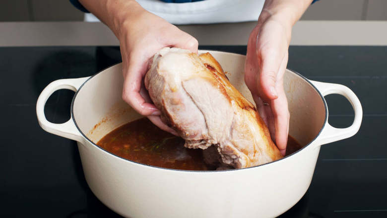 啤酒炖猪肩,将猪肉放回锅中，盖上盖子，整锅转移到烤箱中。以150度烤3小时，然后拿下锅盖，继续烤1小时，或直至猪肉变软。将猪肉放到砧板上，用铝箔包住，以保持温热。